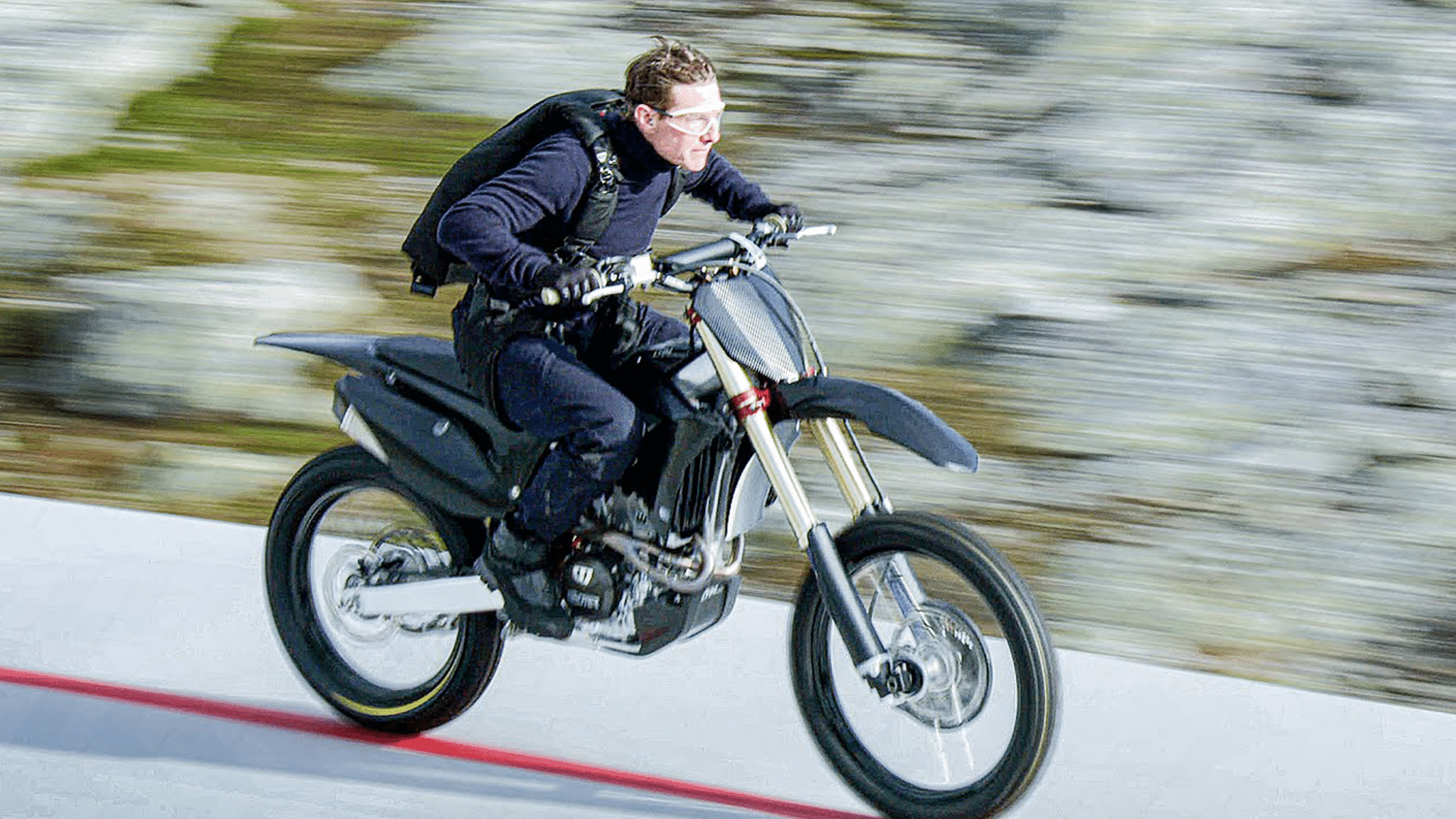 Ethan Hunt aka Tom Cruise riding a bike in <yoastmark class=